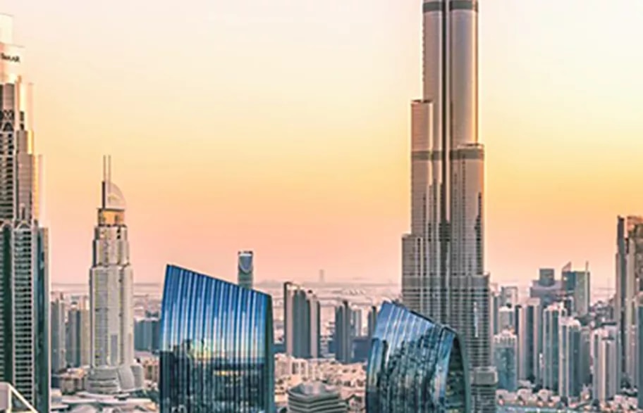 A breathtaking view of Downtown Dubai at sunset, with the iconic Burj Khalifa towering above sleek modern skyscrapers, at Boulevard Plaza, Dubai