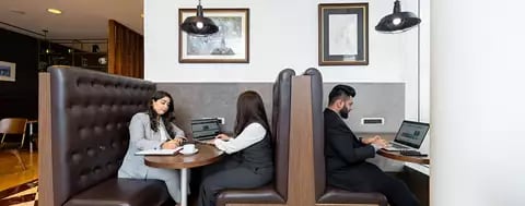 Booth seating in Emirates Towers, Dubai, were people are sitting working 